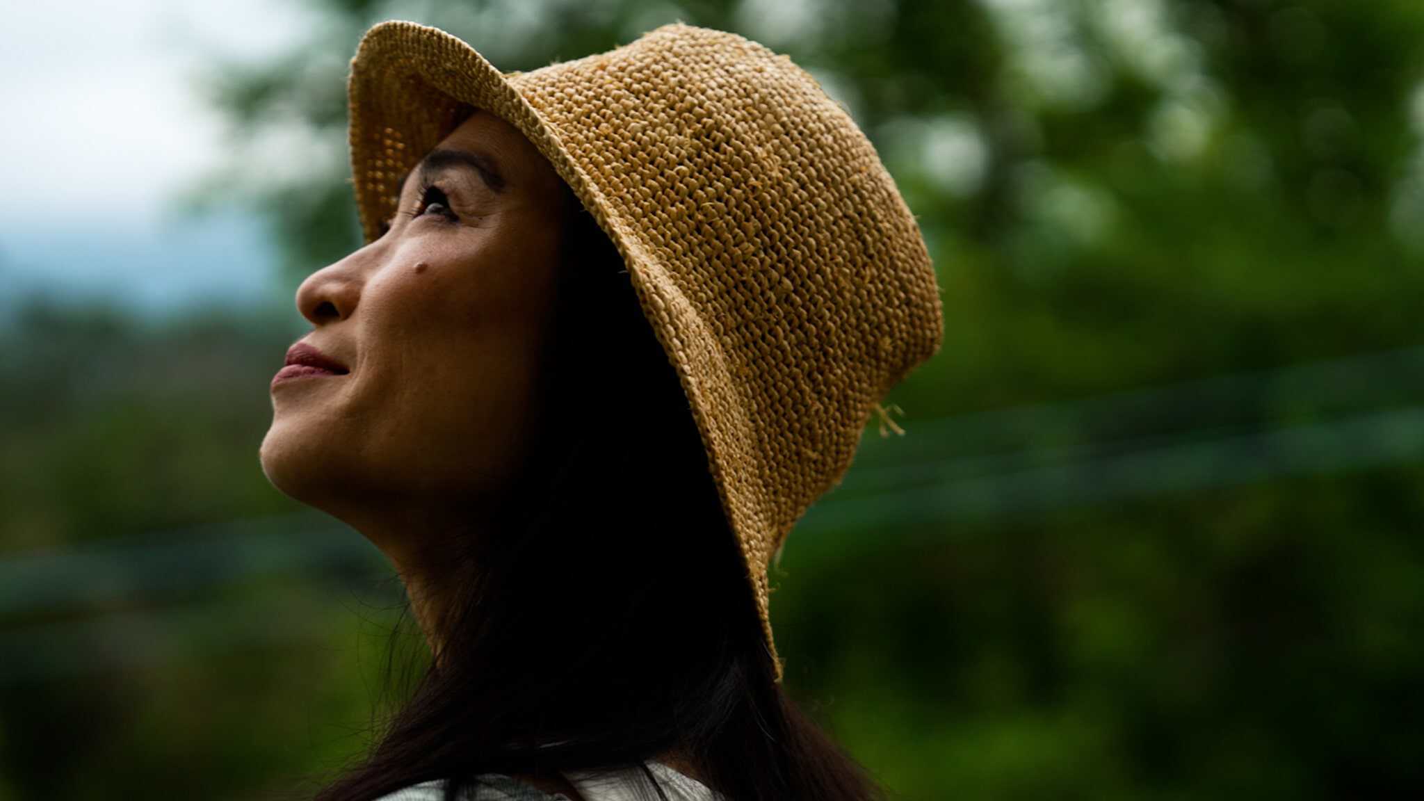 Danielle Chang wearing a hat looking up into the sky.