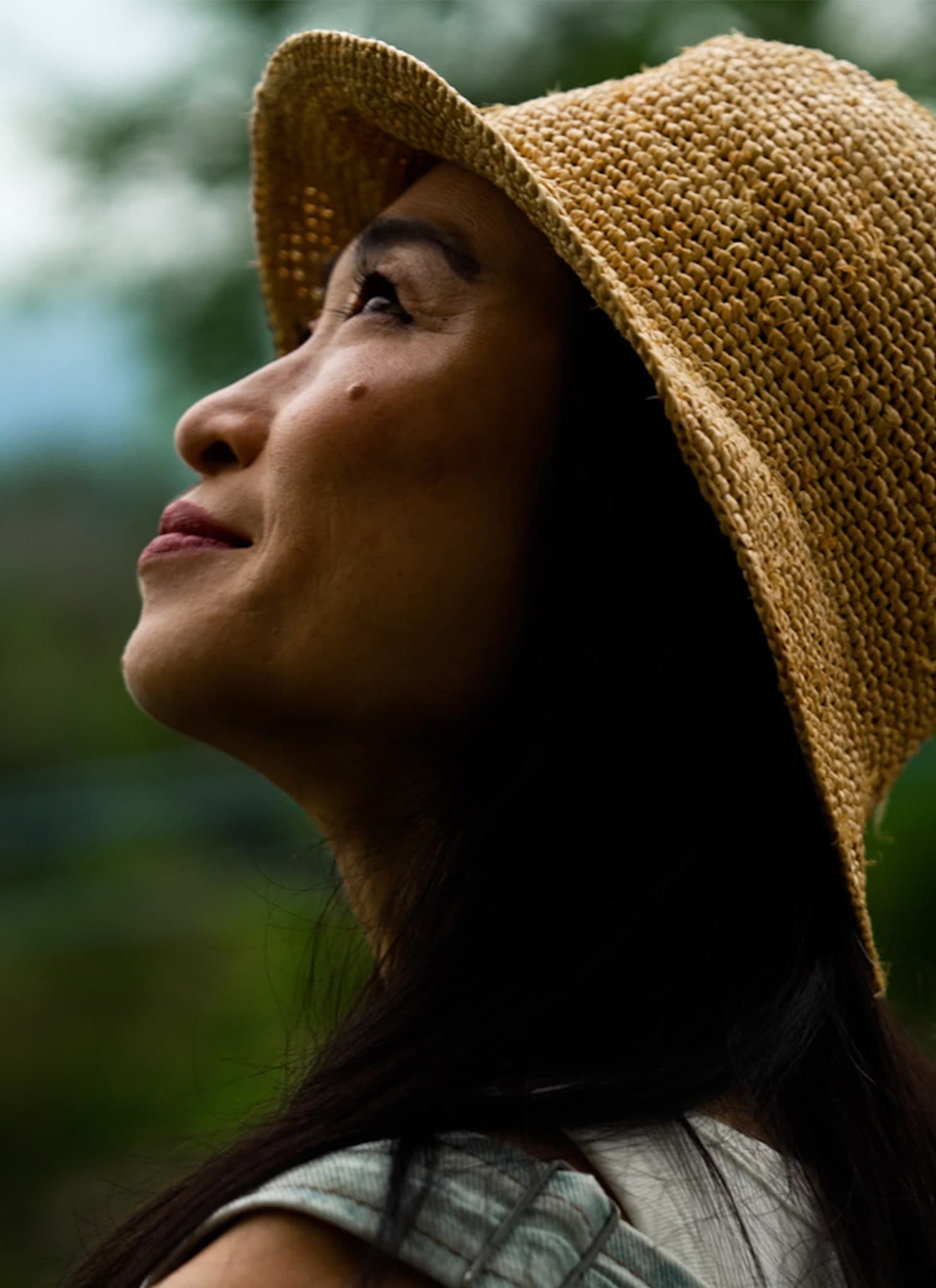 Danielle Chang wearing a hat looking up into the sky.