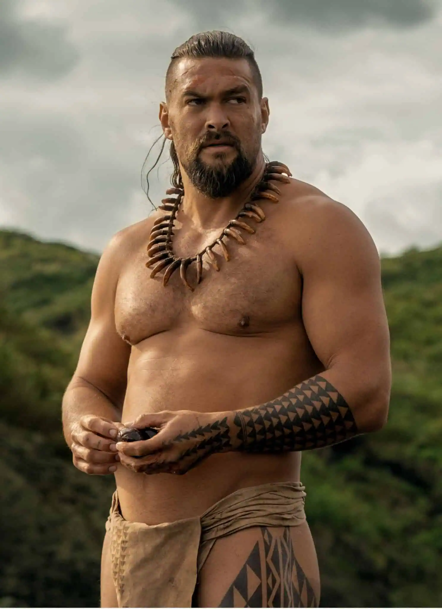 Jason Momoa as Ka’iana in Chief of War, standing shirtless.