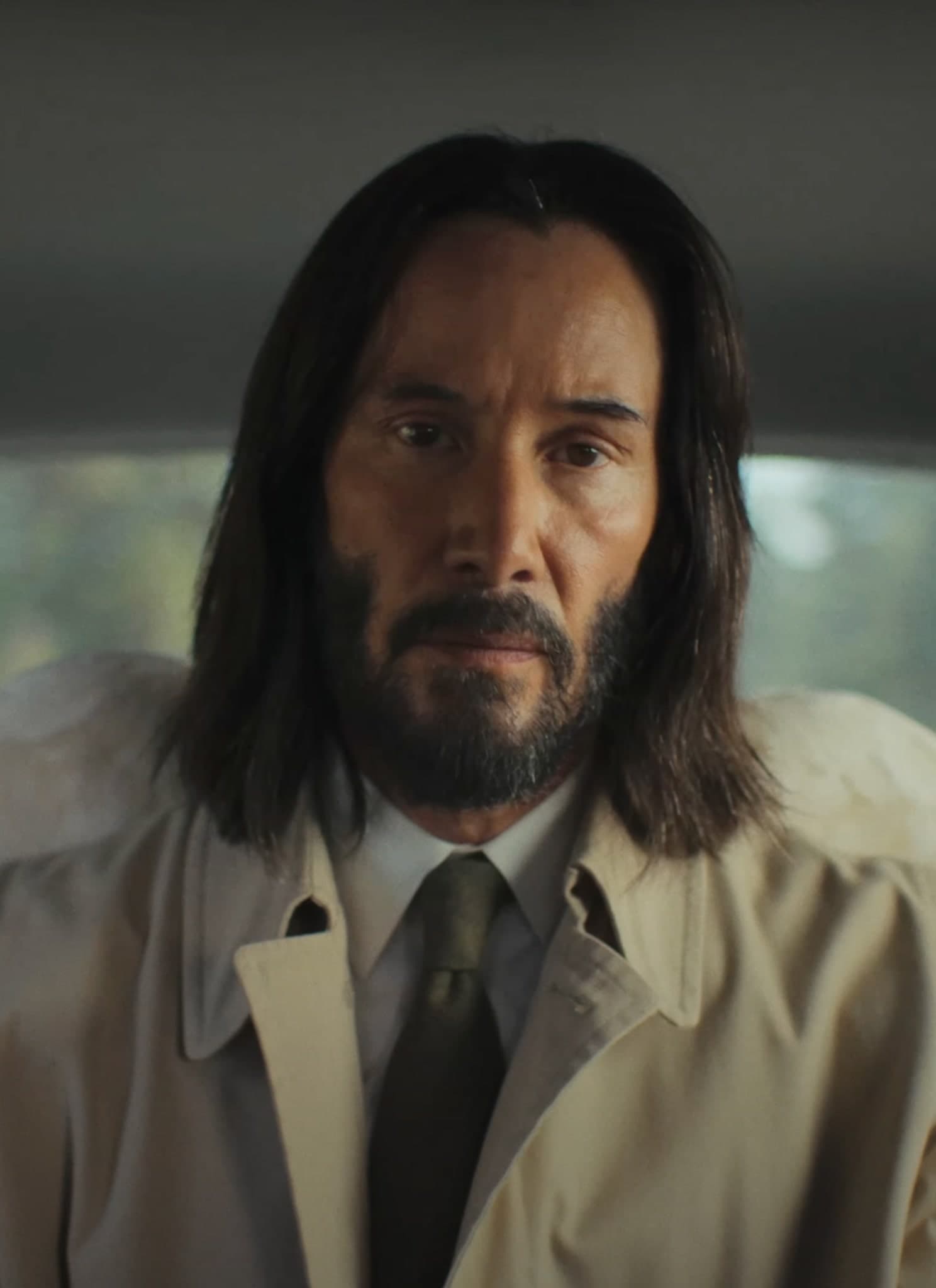 Keanu Reeves in white shirt and beige coat in Good Fortune trailer.