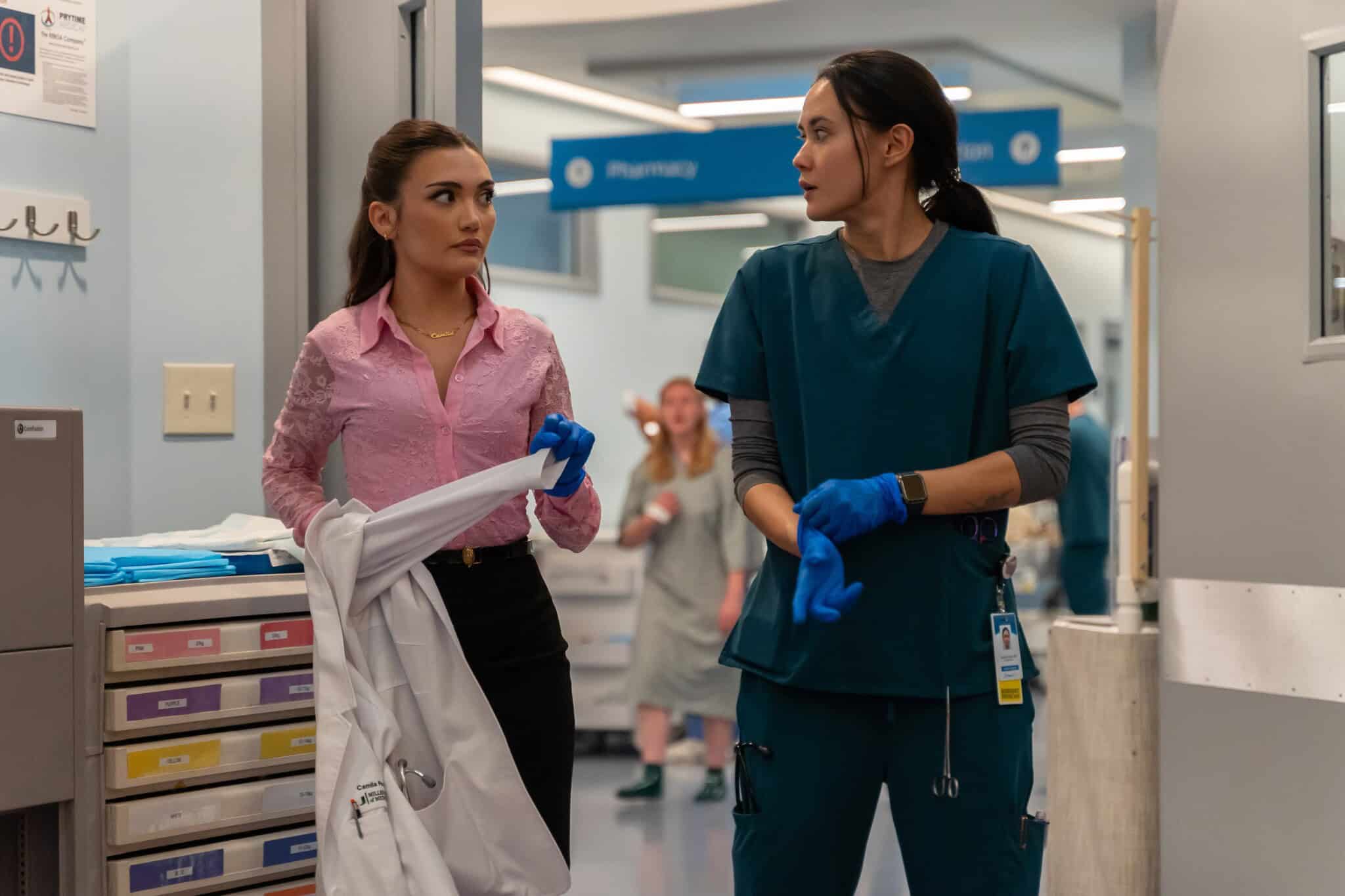 Daniela Nieves in a pink shirt and black top, and Chelsea Muirhead in teal hospital scrubs on "Pulse."