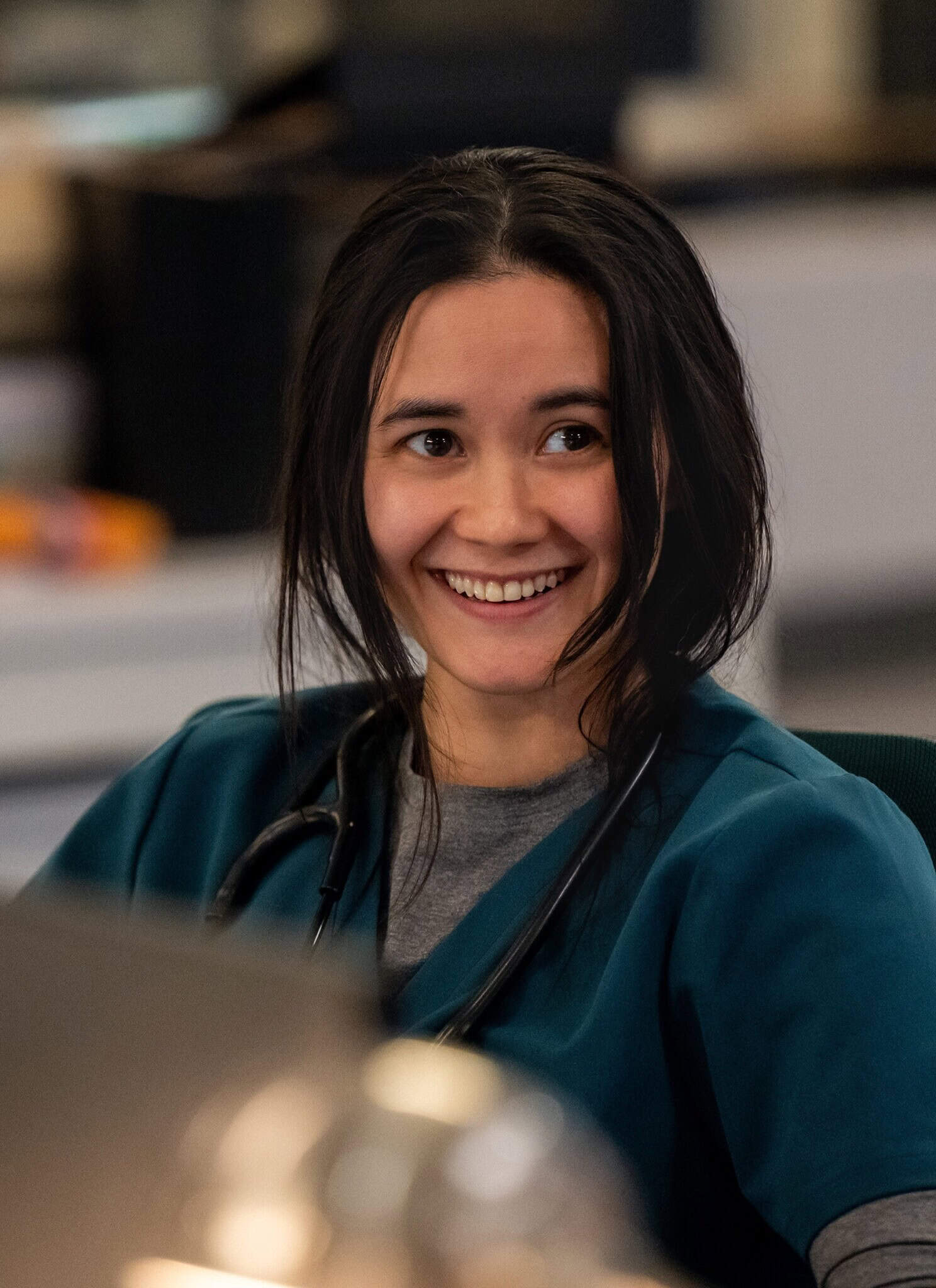 Actress Chelsea Muirhead in teal hospital scrubs on the show "Pulse."