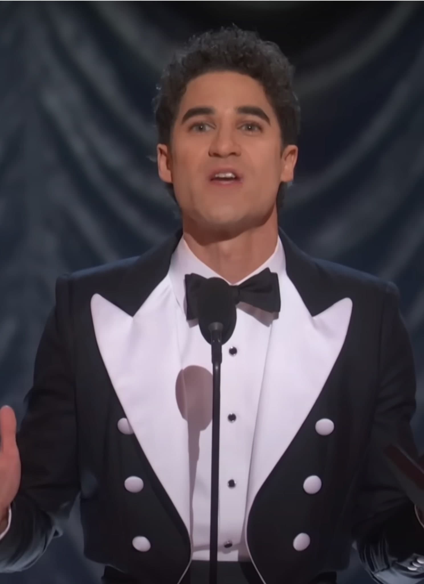 Darren Criss in black and white tux holding Tony.