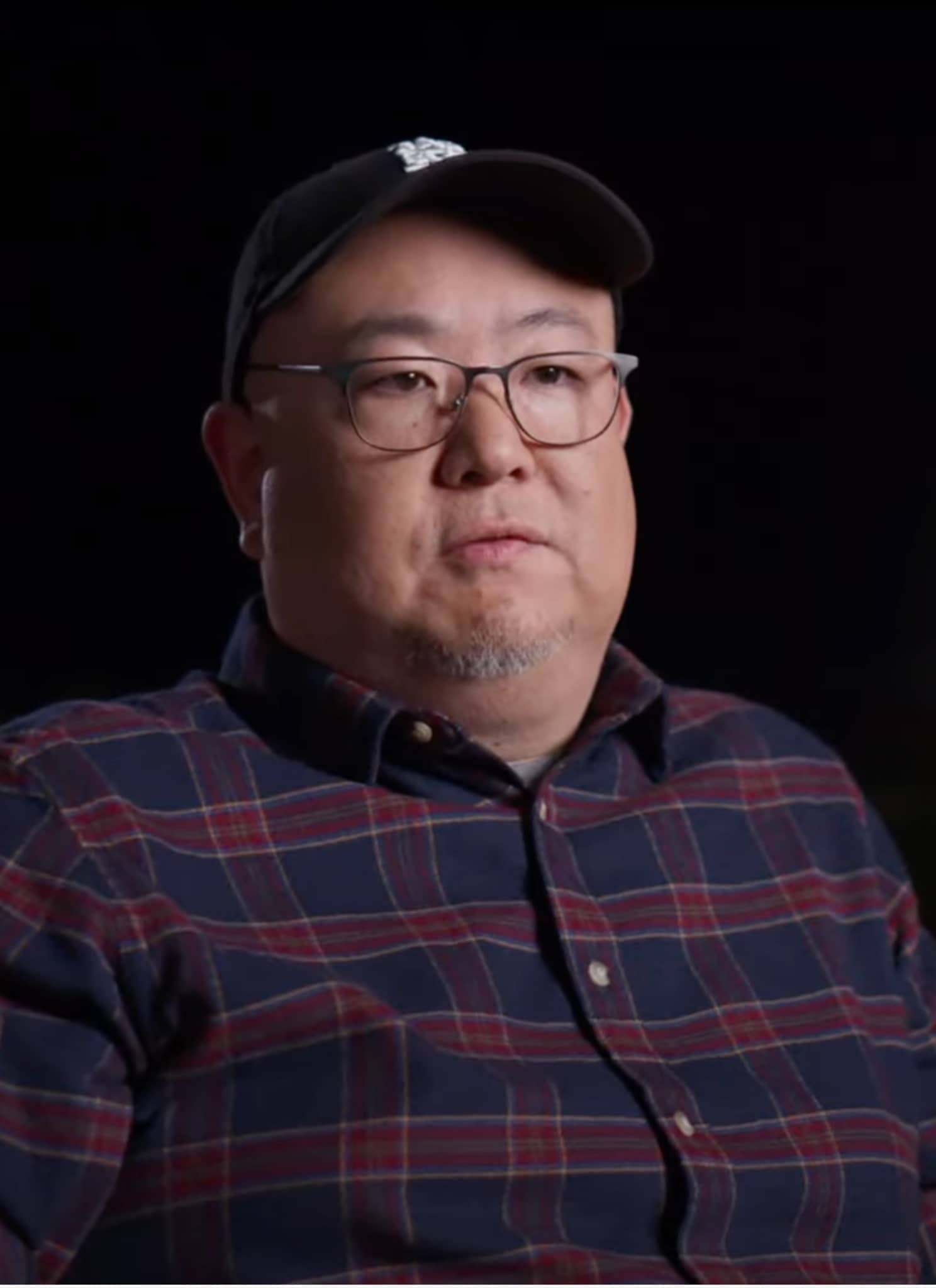 Peter Sohn sitting with black cap and flannel shirt.
