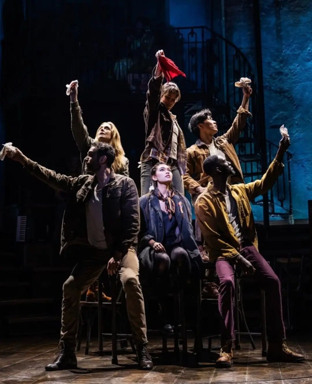 Myra sitting in the center of five Hadestown ensemble members.
