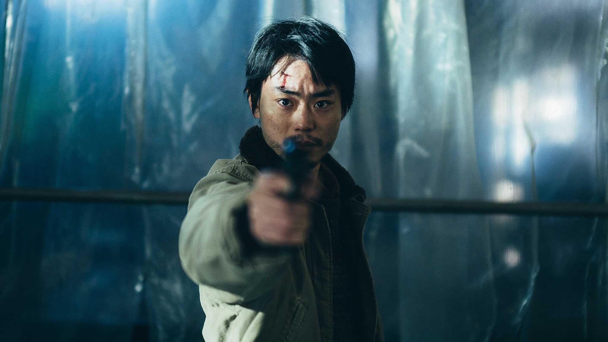 Masaki Suda as Ryosuke Yoshii holding gun wearing green jacket