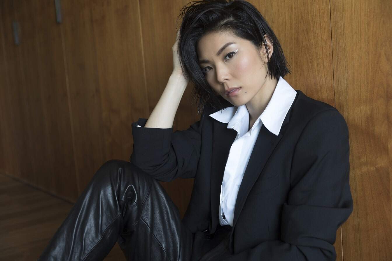 MASUMI wearing a black jacket and white shirt.