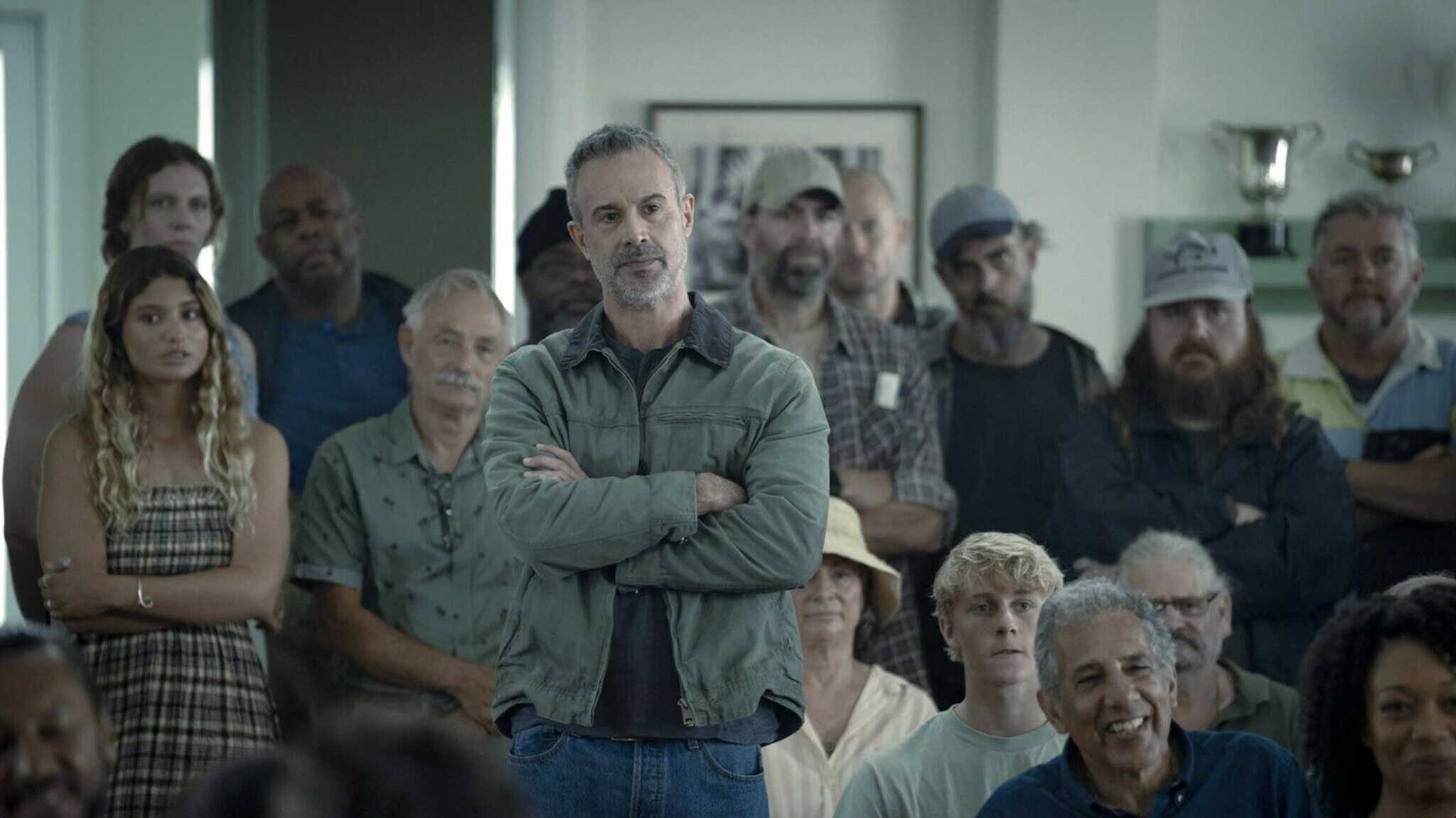 Freddy Prinze Jr. stands in a crowd of people sitting and standing in "I Know What You Did Last Summer."