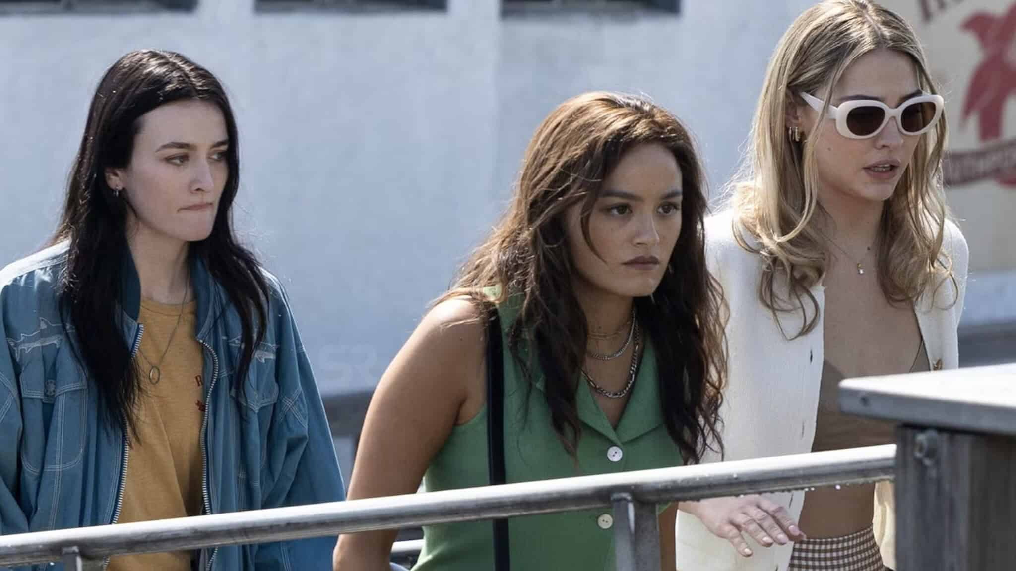 Actrors Sarah Pidgeon, Chase Sui Wonders and Madelyn Cline stand behind a railing in 