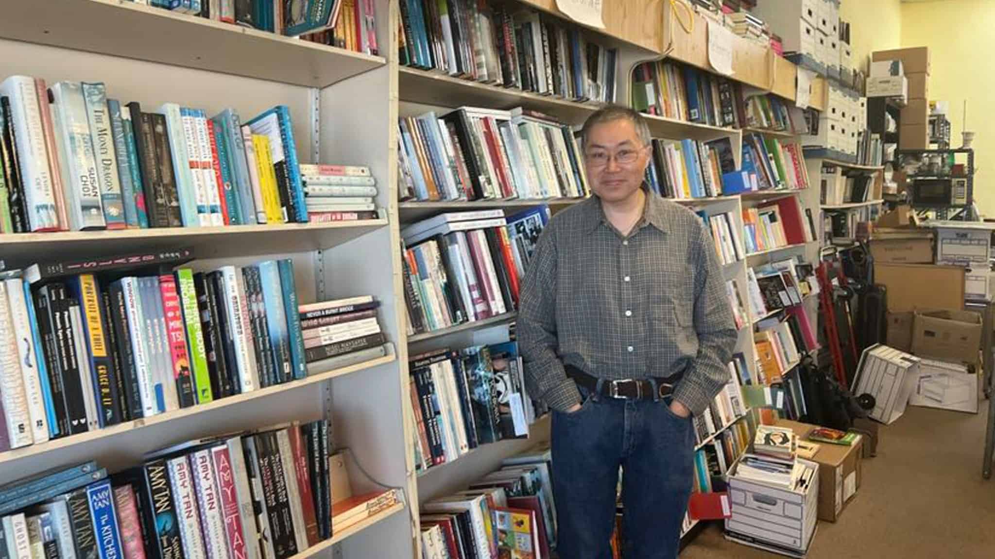 Leonard Chan in gray shirt standing inside his bookstore