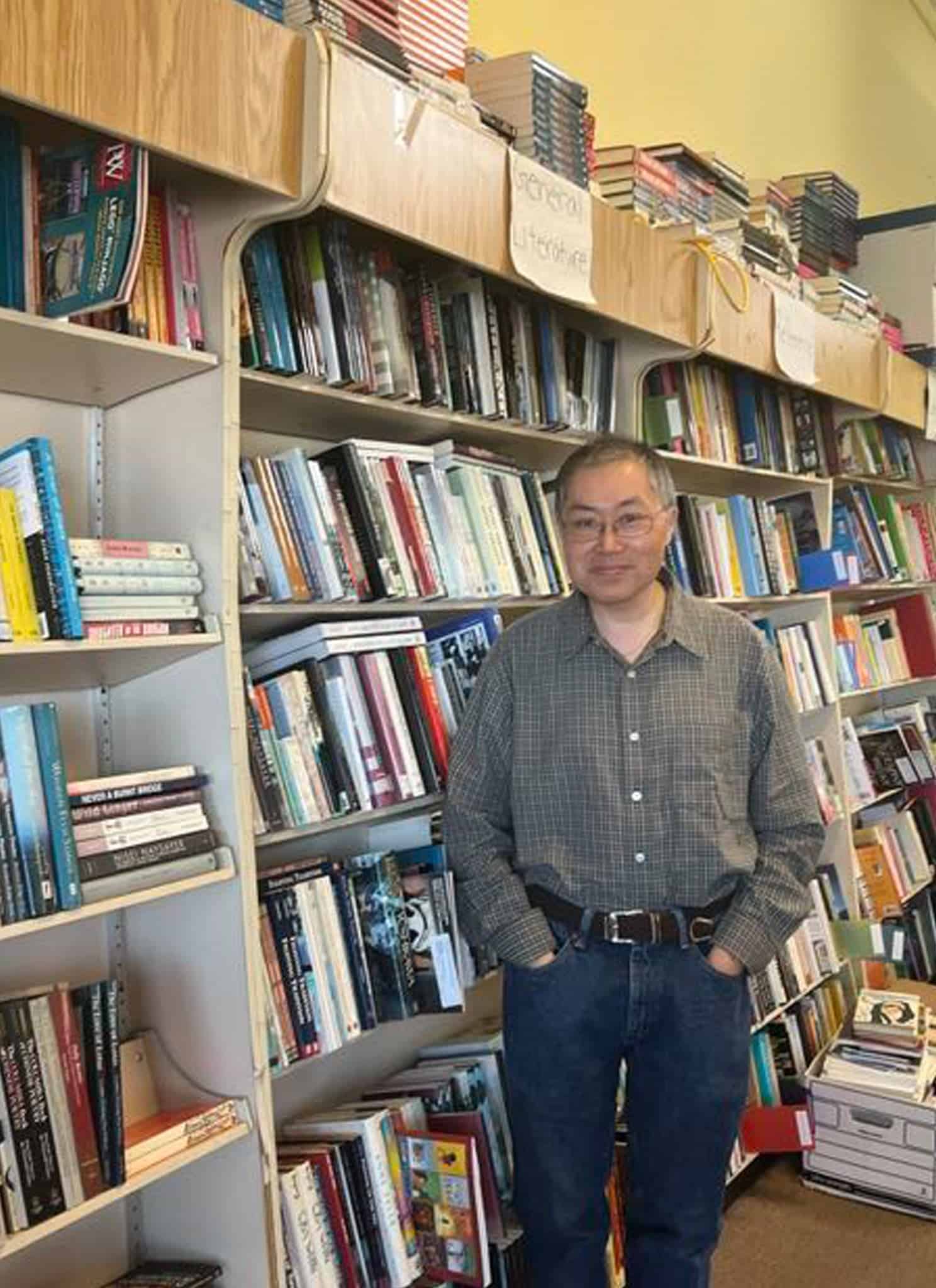 Leonard Chan in gray shirt standing inside his bookstore