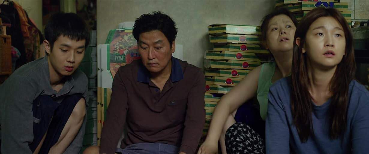 Actors Choi Woo-shik, Lee Sun-kyun, Cho Yeo-jeong and Park So-dam sit together with pizza boxes in the background in "Parasite."