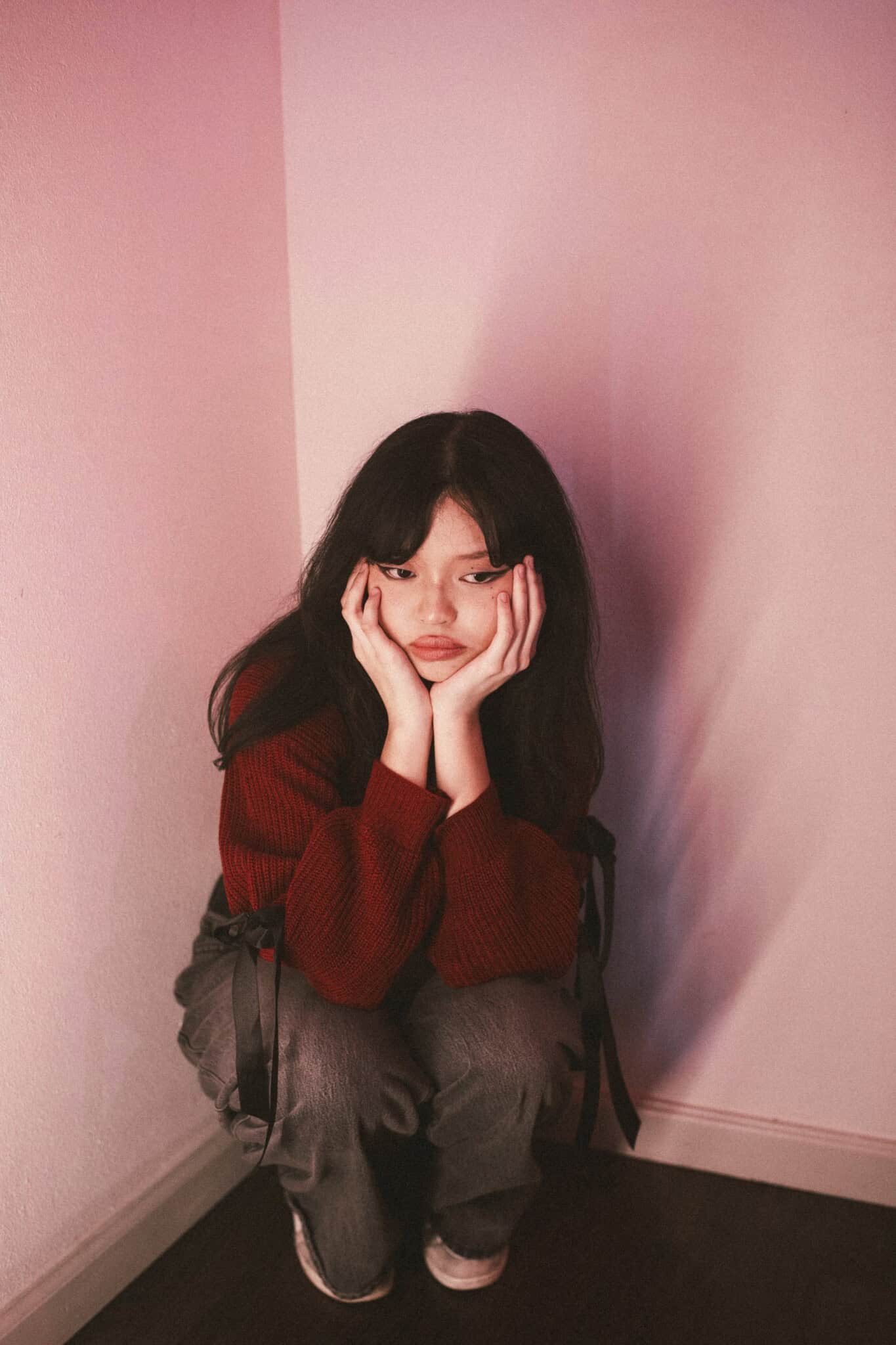 Lyn Lapid kneeling, resting her head in her hands.