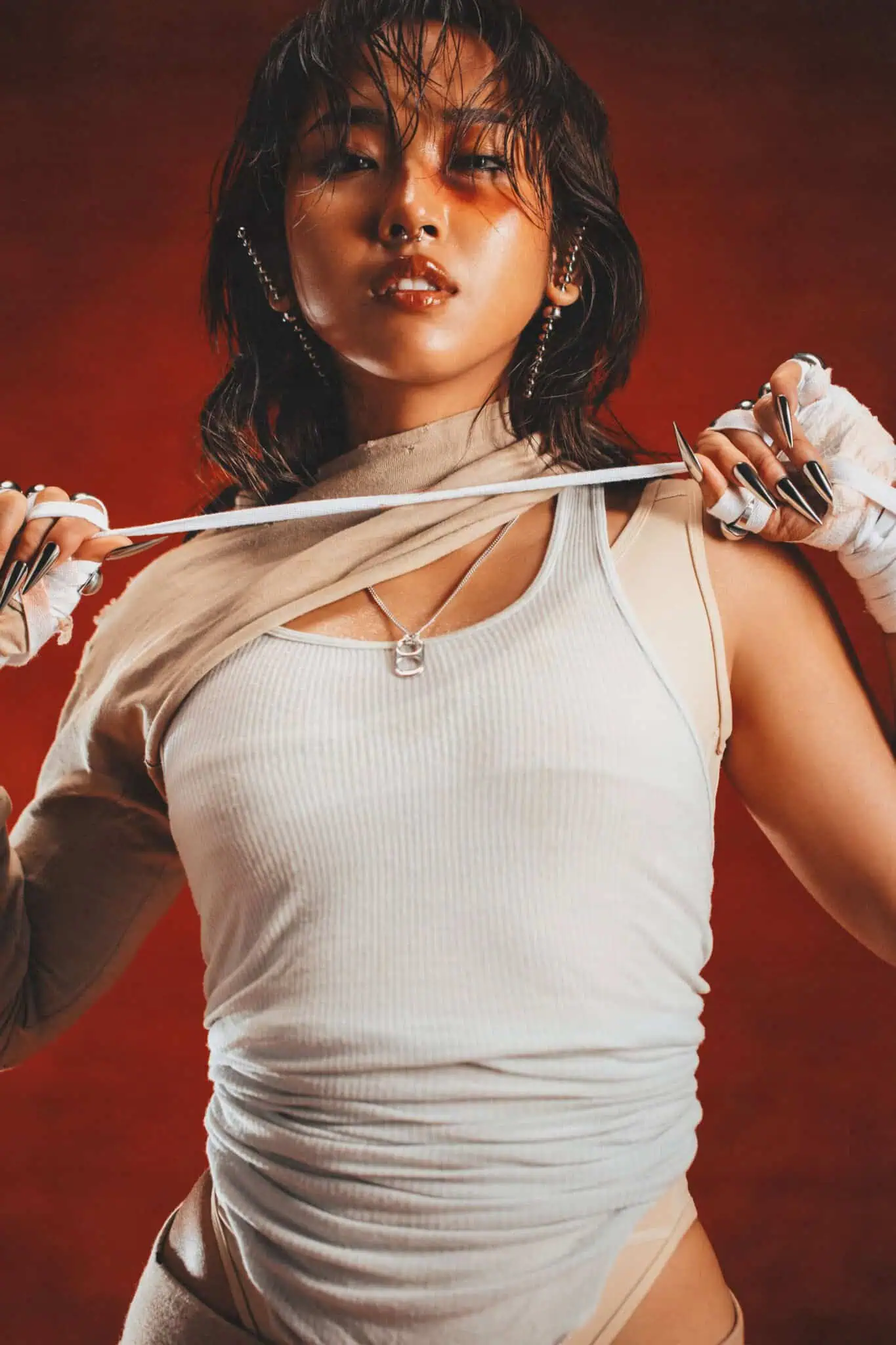 MILLI in a white outfit in front of a red background.