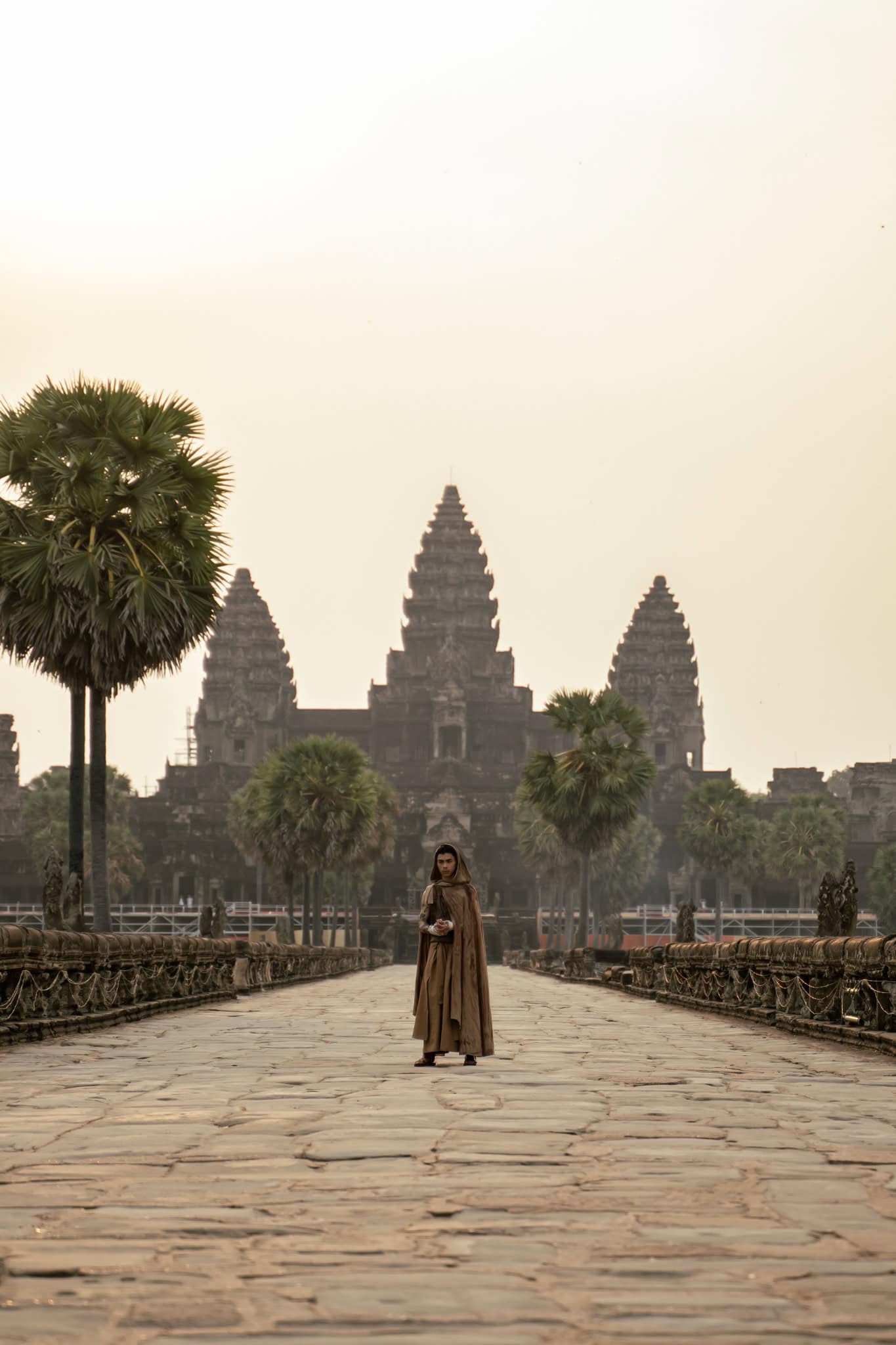 Rapper VannDa in a hooded robe, in front of Angkor Wat in Cambodia.