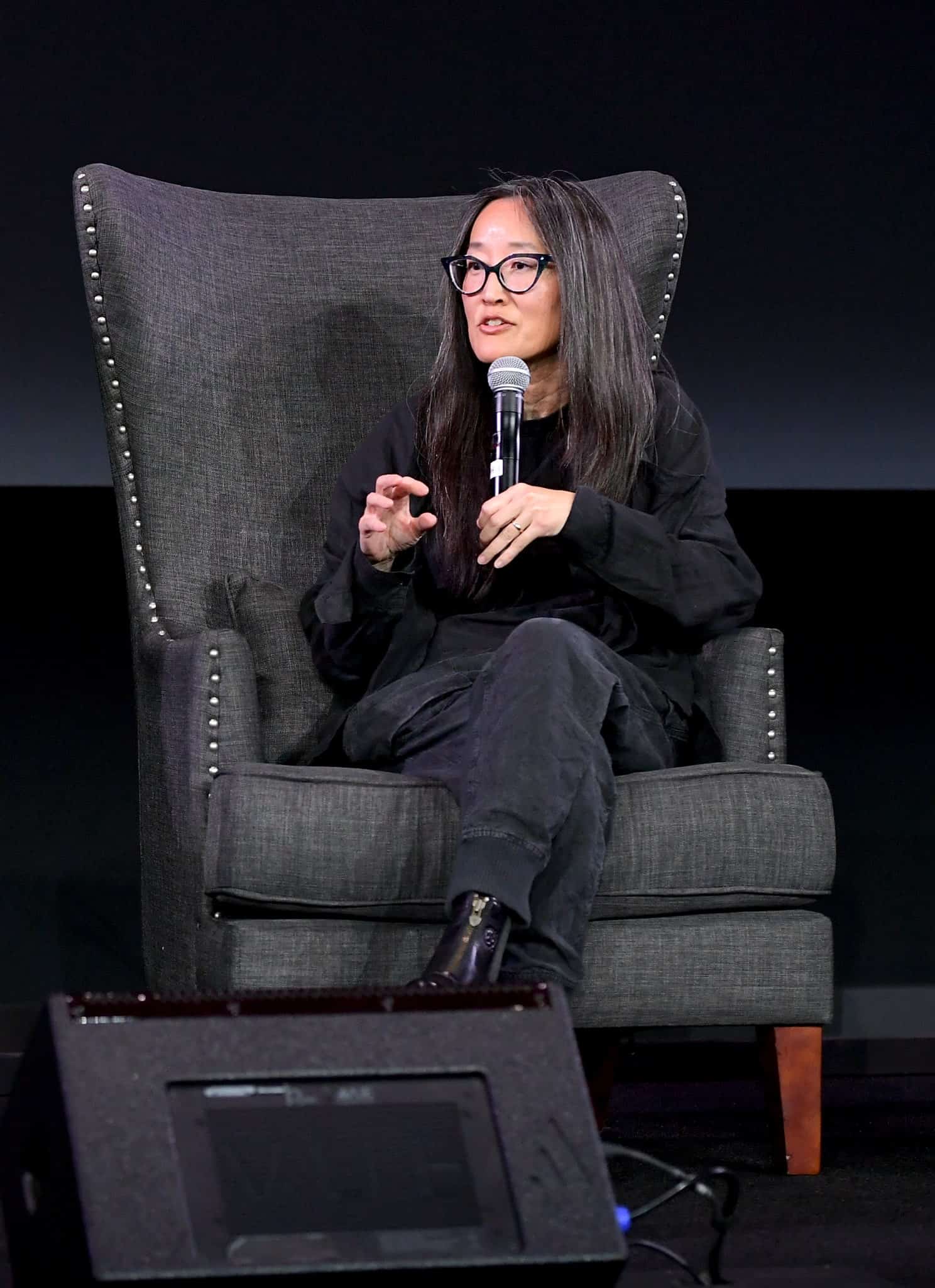 A man and woman sitting in chairs with microphones.