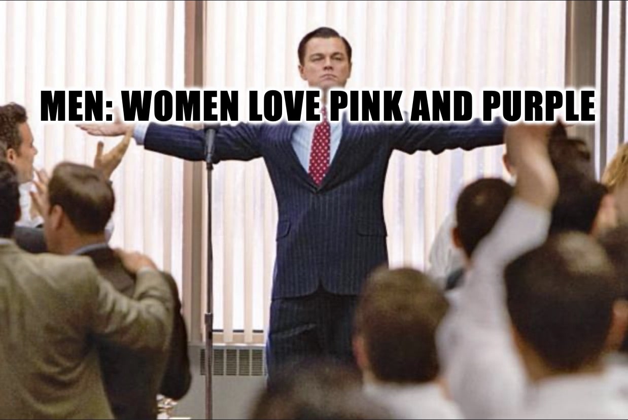 A man in a suit stands confidently with arms outstretched before a cheering crowd. Bold text across the image reads: MEN: WOMEN LOVE PINK AND PURPLE.