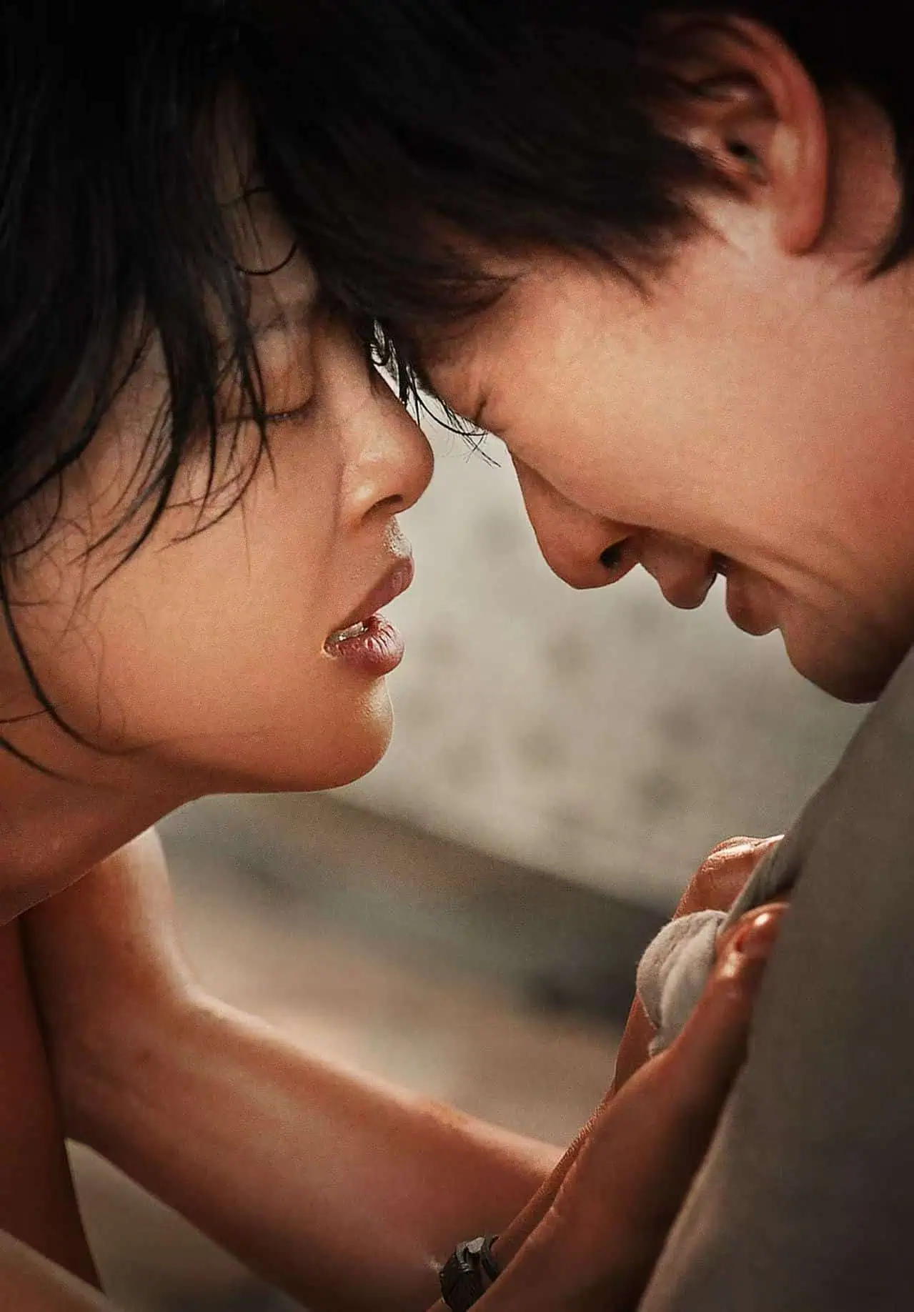 Two people with their faces very close, eyes closed and foreheads touching, appear emotional and distressed, possibly crying or about to cry.