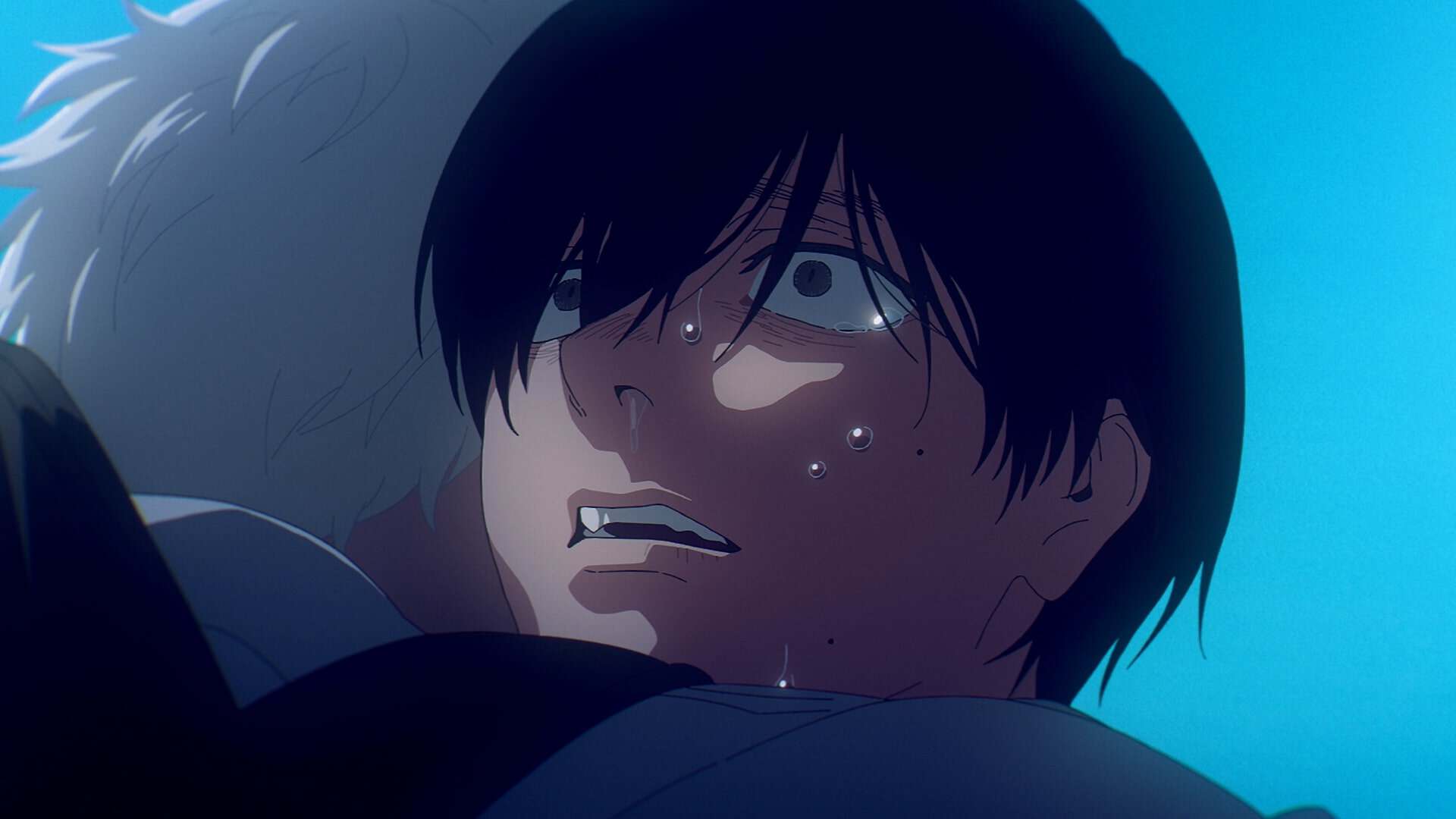 A close-up of an anime character with dark hair and wide, anxious eyes, sweating and looking distressed while being hugged by another person with light hair against a blue background.