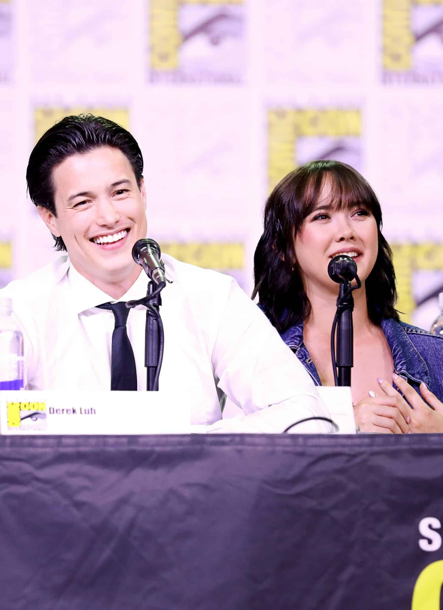 Two panelists, Gen V stars London Thor and Derek Luh, sit at a Comic-Con table with microphones, smiling and speaking. Name placards are in front of them and the backdrop features the Comic-Con International logo.