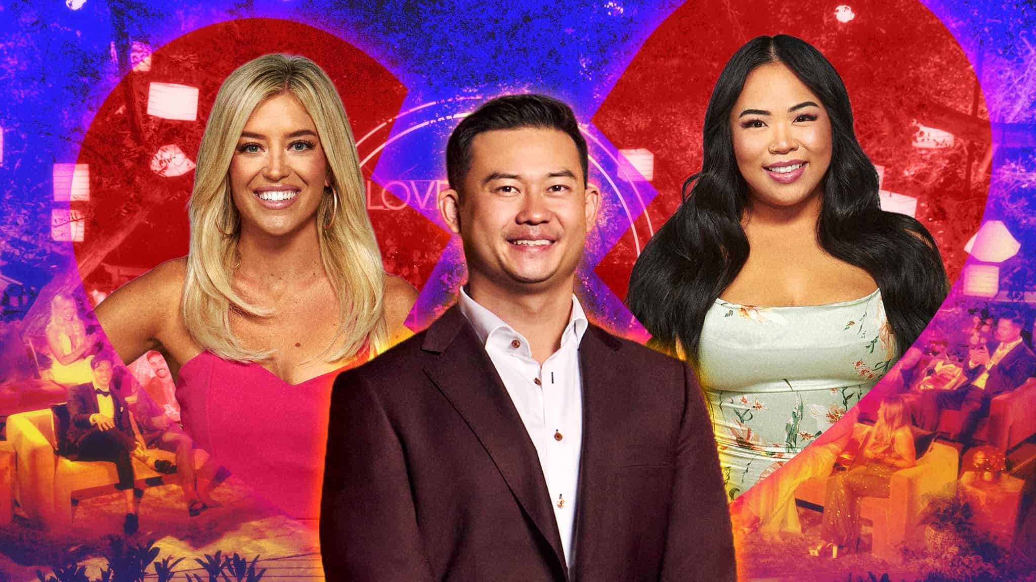 Three people, two women and a man, stand in front of a colorful background featuring a broken heart shape and an audience. The women are smiling, and the man is wearing a suit and also smiling.