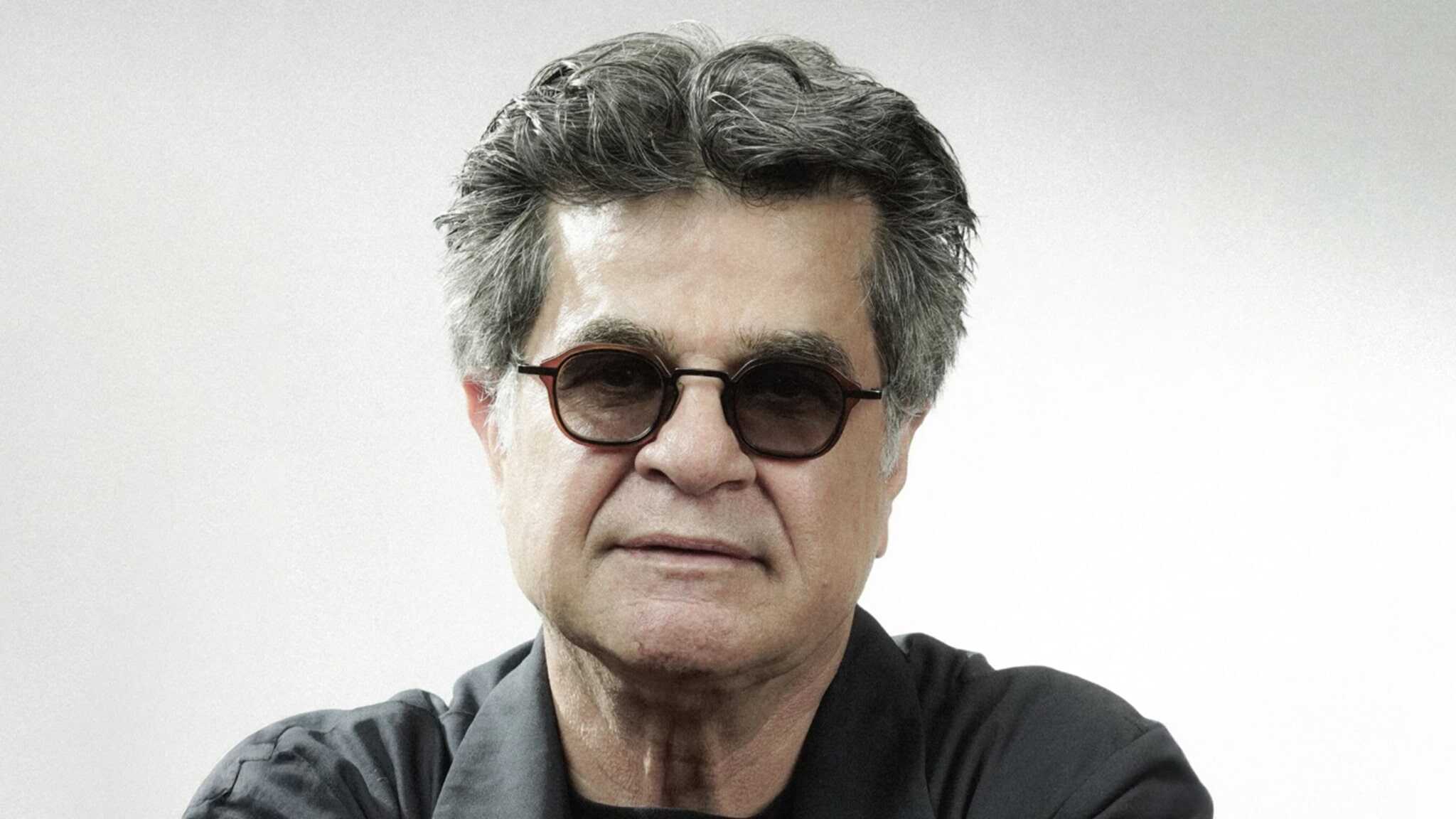 A middle-aged man with gray hair and glasses is wearing a dark shirt and looking directly at the camera against a plain light background.