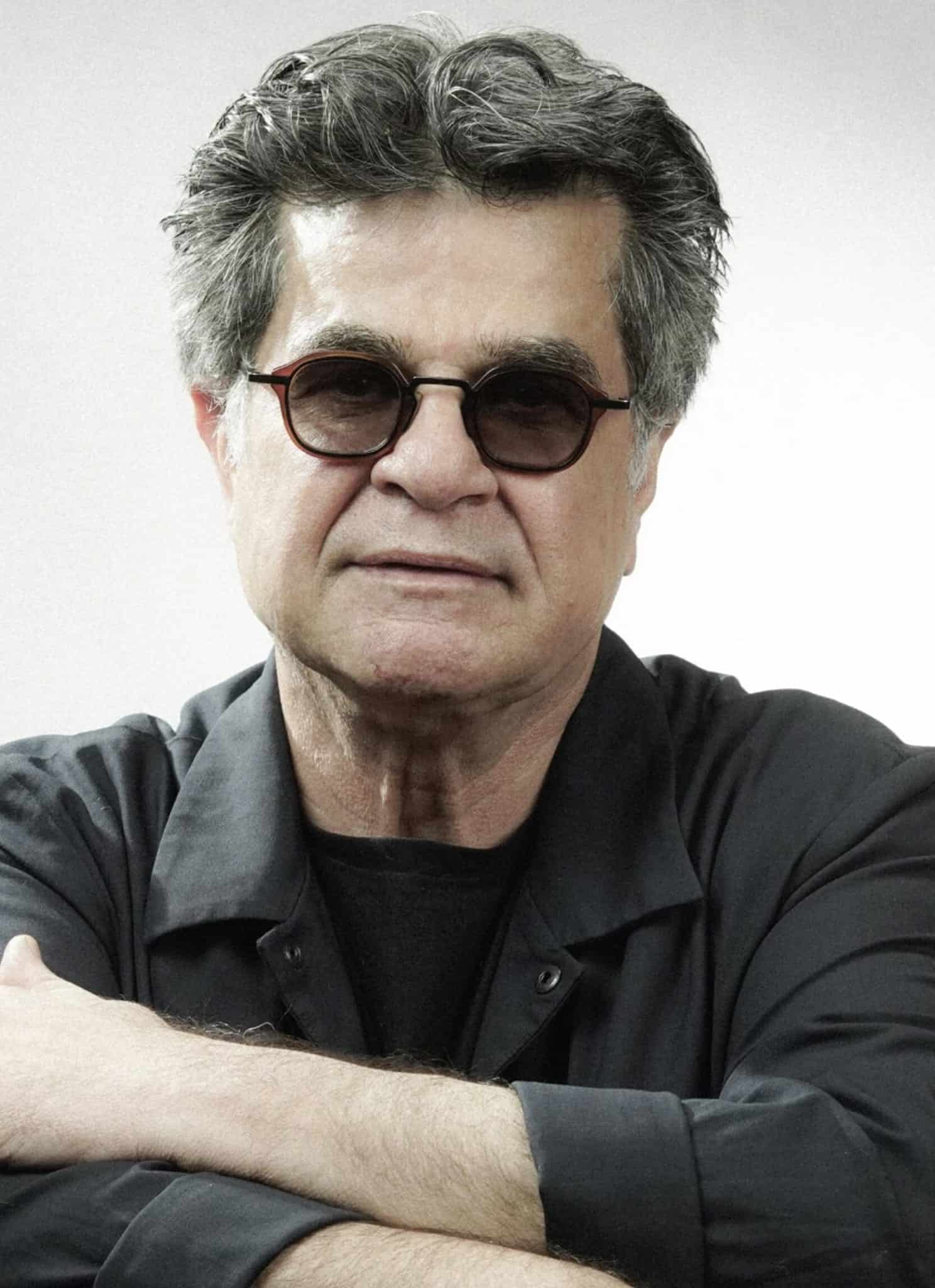 A middle-aged man with gray hair and glasses is wearing a dark shirt and looking directly at the camera against a plain light background.