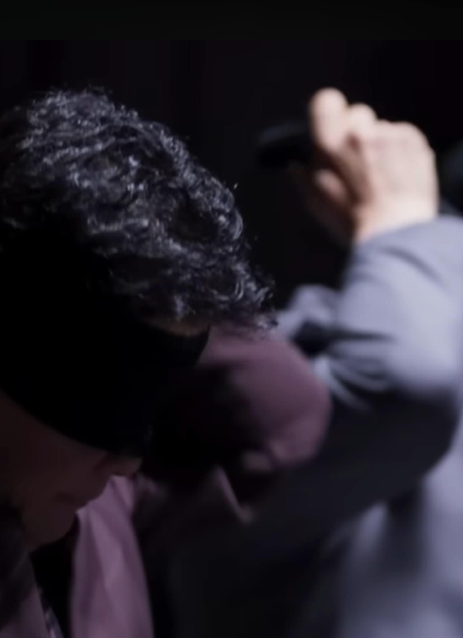 Two people in suits, caught in the intrigue of Culinary Class Wars, put black blindfolds over their eyes, both facing slightly downward in a dimly lit setting.