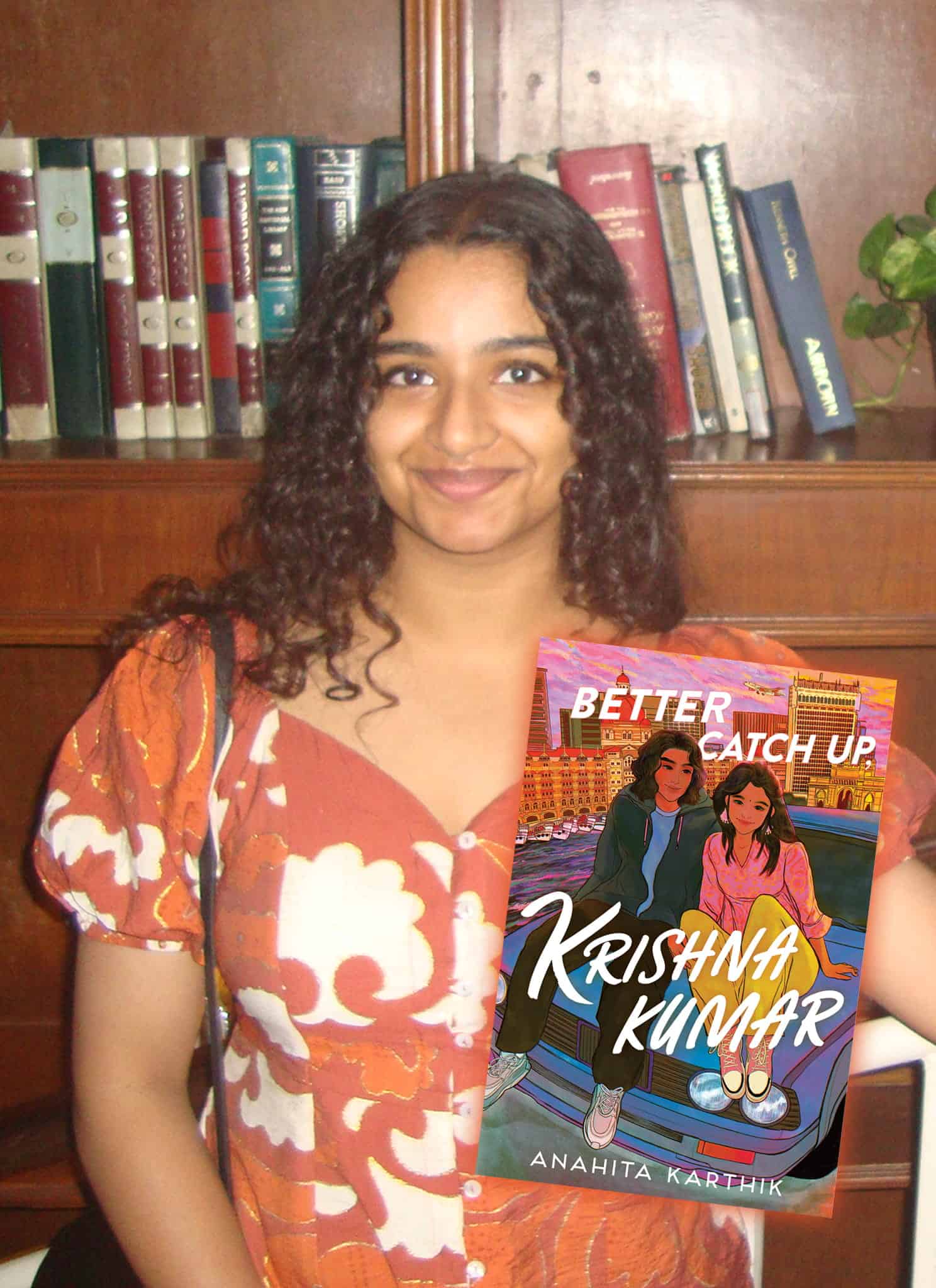 A smiling woman in a floral dress stands in front of a bookshelf, next to a book cover that reads Better Catch Up, Krishna Kumar by Anahita Karthik, featuring illustrated teens sitting on a car’s hood.