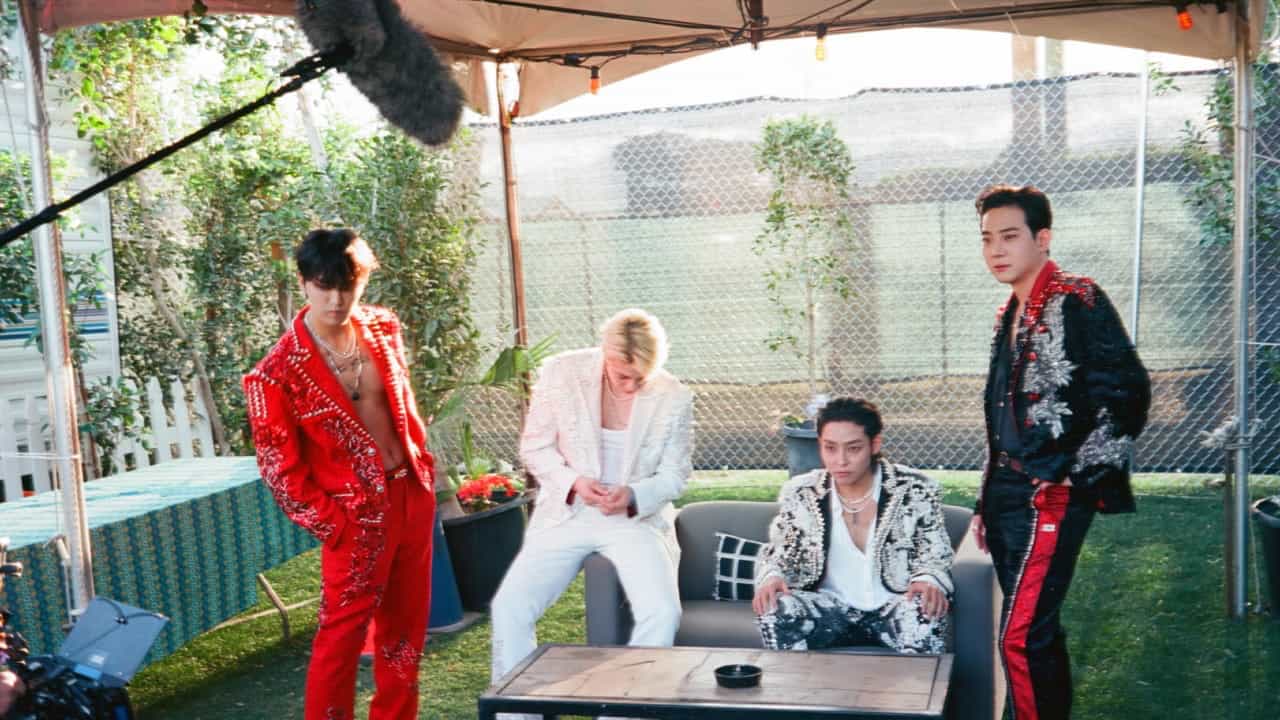 A group of men in matching outfits, reminiscent of The Rose, stands together in perfect harmony.