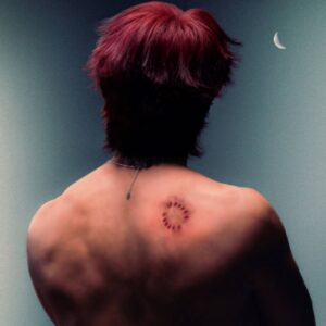 A person with short red hair faces away, showing a circular bite mark on their bare upper back. The background is dark with a crescent moon visible in the top right corner.
