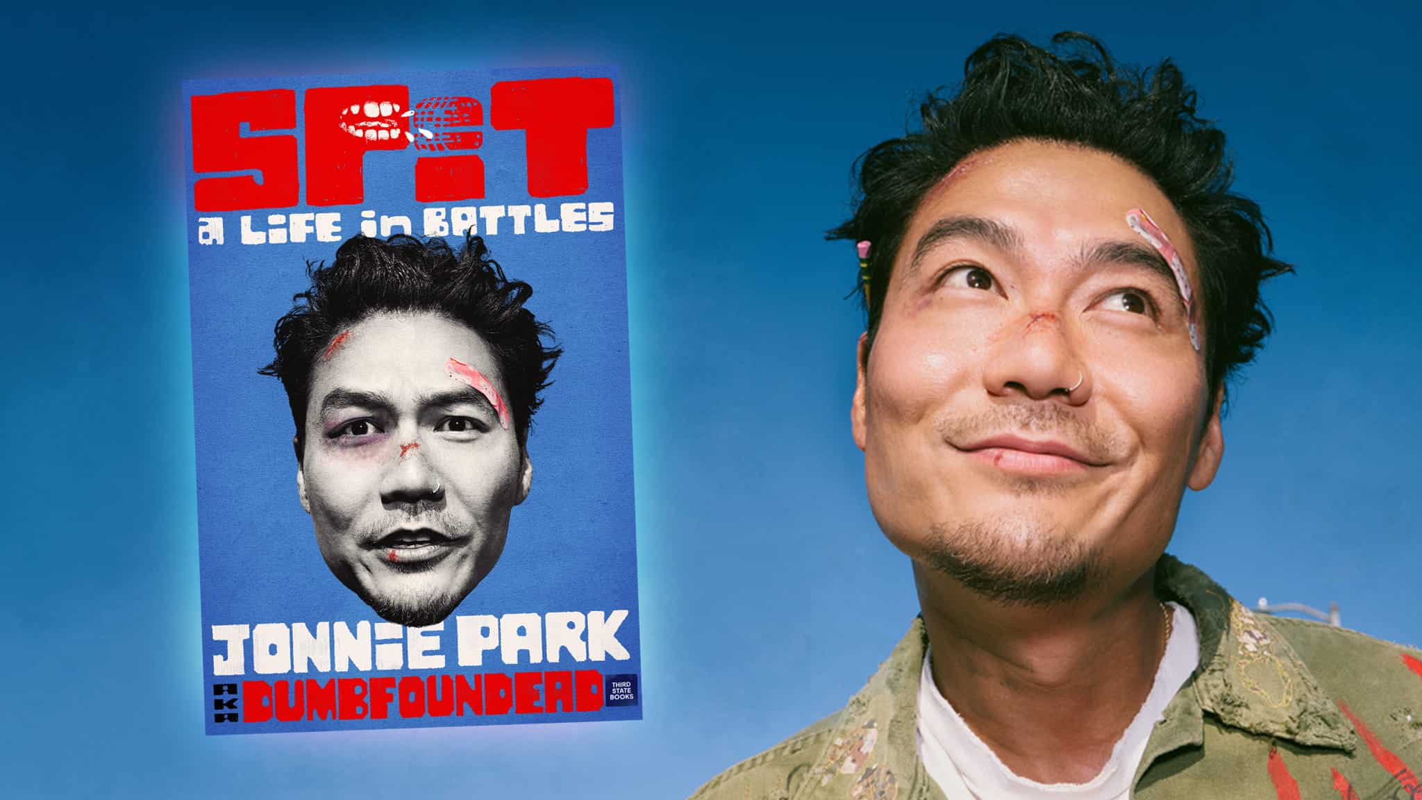 A man with bandages on his face smiles against a blue background. Next to him is a poster with his face, red bold text SPIT, and the names Jonnie Park and Dumbfounded. The poster reads A Life in Battles.