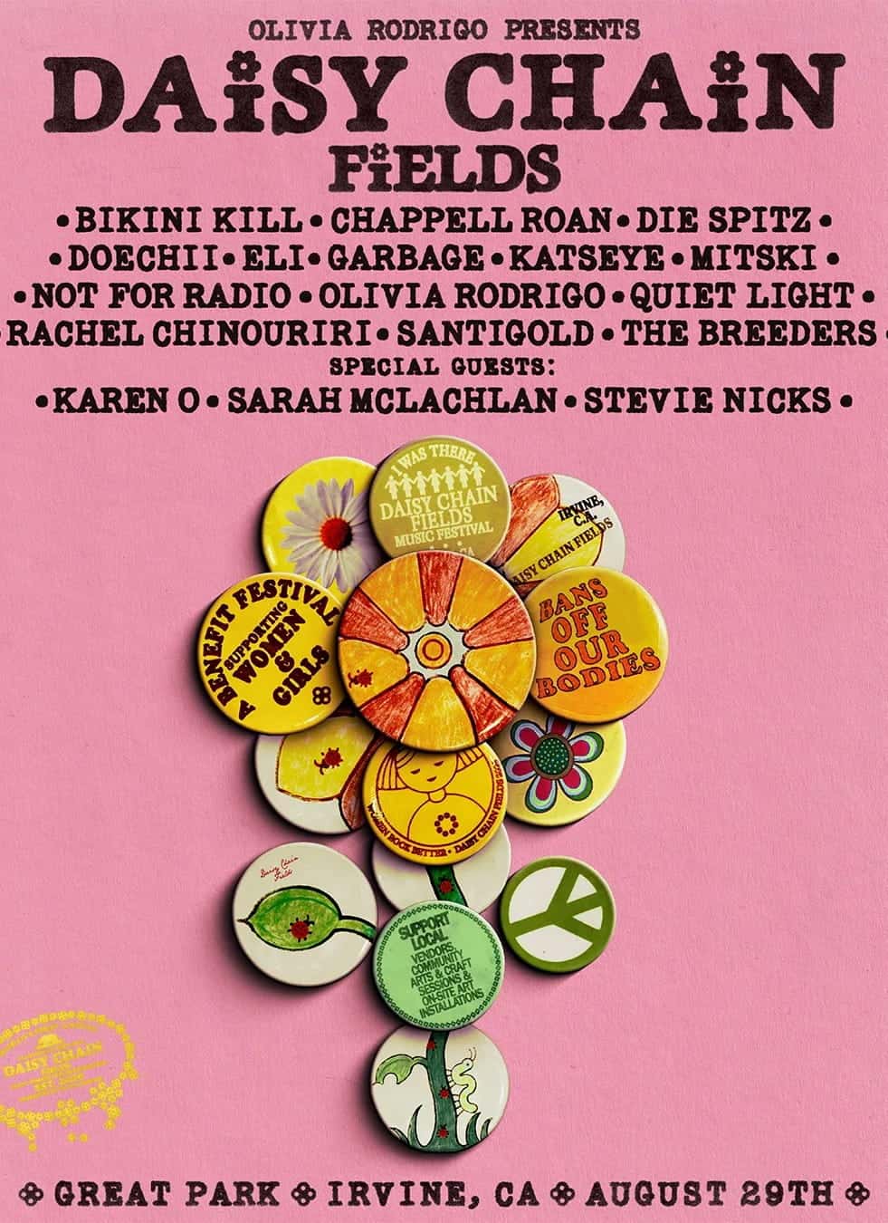 A cluster of vintage feminist and peace-themed buttons with slogans like Womens Festival, Mans Off Our Bodies, and Support Local, Think Global, arranged on a pink Daisy Fields background.