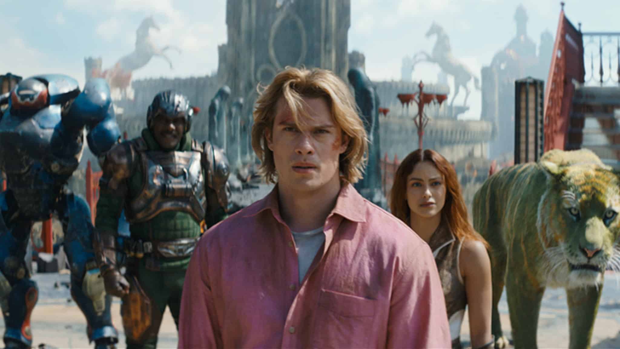 A young man in a pink shirt stands in front of a woman, armored figures, and a green tiger, with a fantasy city featuring statues and ruins in the background under a bright sky.