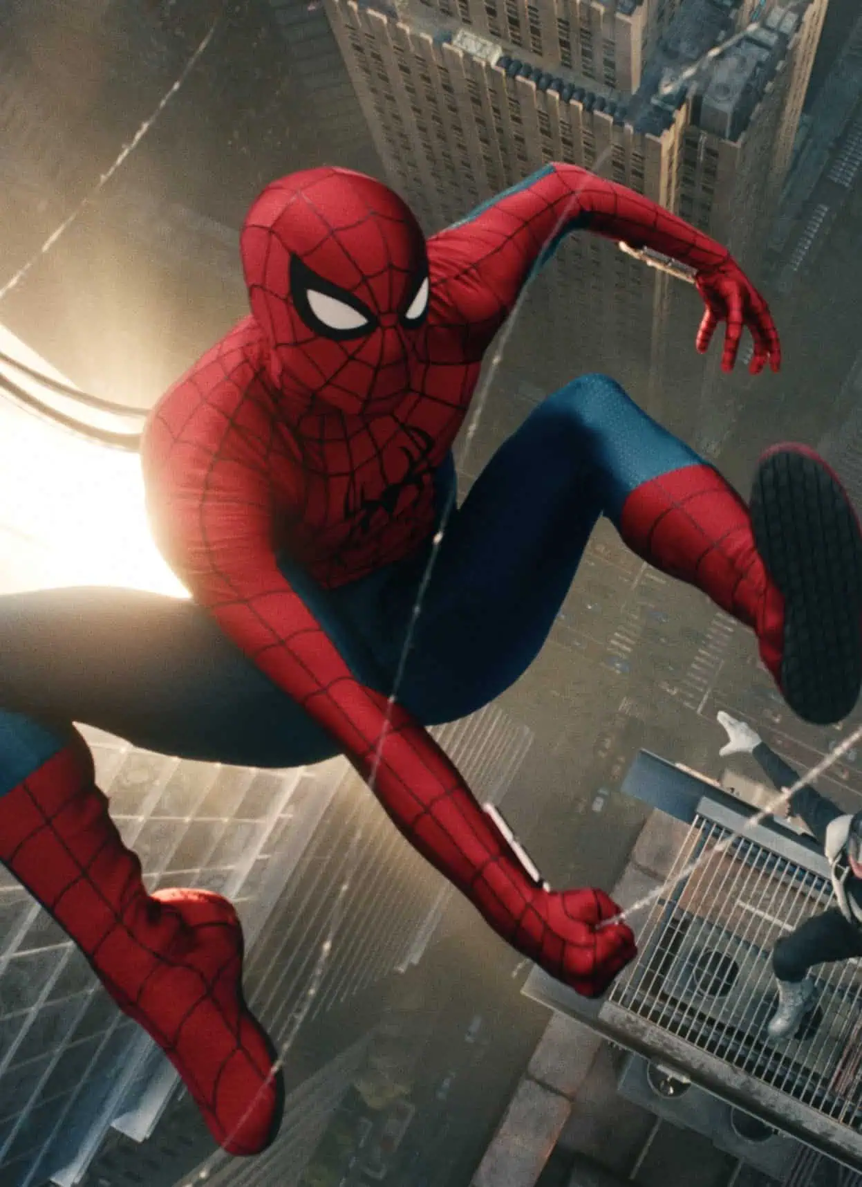 Spider-Man swings high above a city, with skyscrapers below him. Another costumed character leaps nearby, both appearing in action mid-air.
