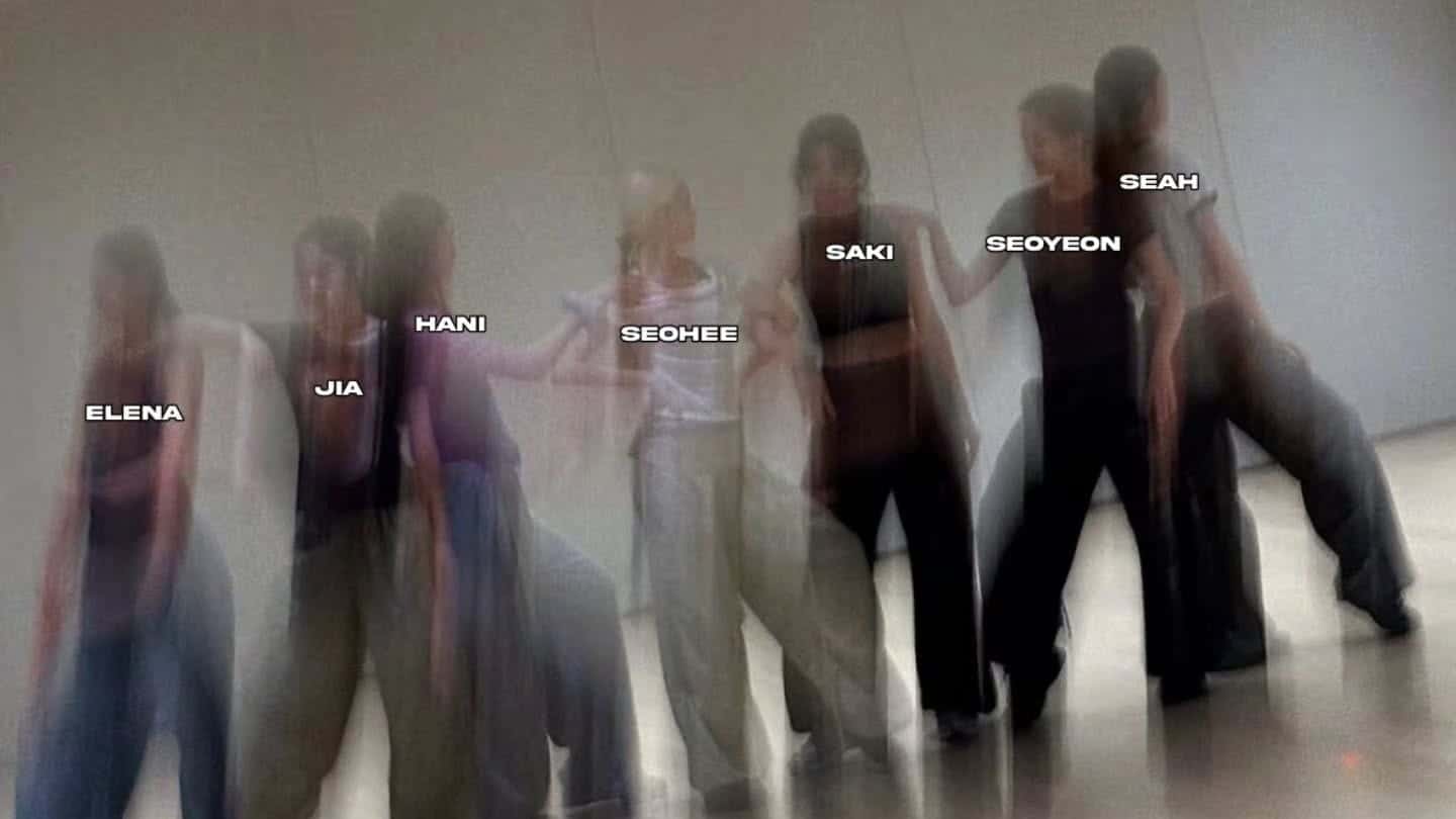 Seven women in loose pants and tops dance in a studio. Their names, Elena, Jia, Hani, Seohee, Saki, Seoyeon, and Seah, appear over each person. The motion blur effect shows dynamic movement.