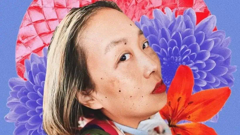 A woman with light skin and red lipstick poses in front of a collage background with purple and red flowers and a red textured pattern on a blue backdrop.