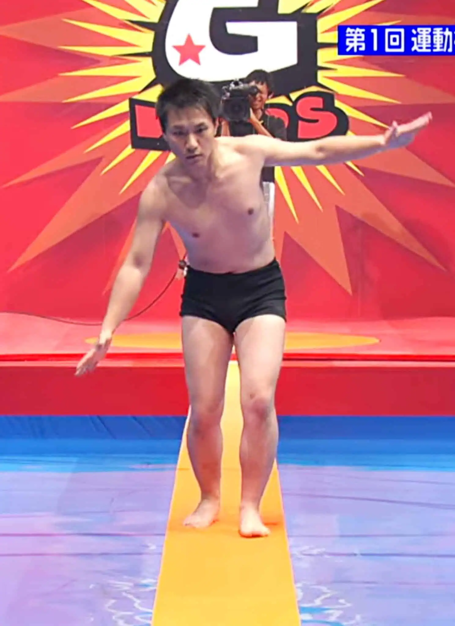 A man balances on a narrow yellow platform in a colorful game show set. A scoreboard displays 4m 90 in yellow. An inset shows a commentators face reacting.