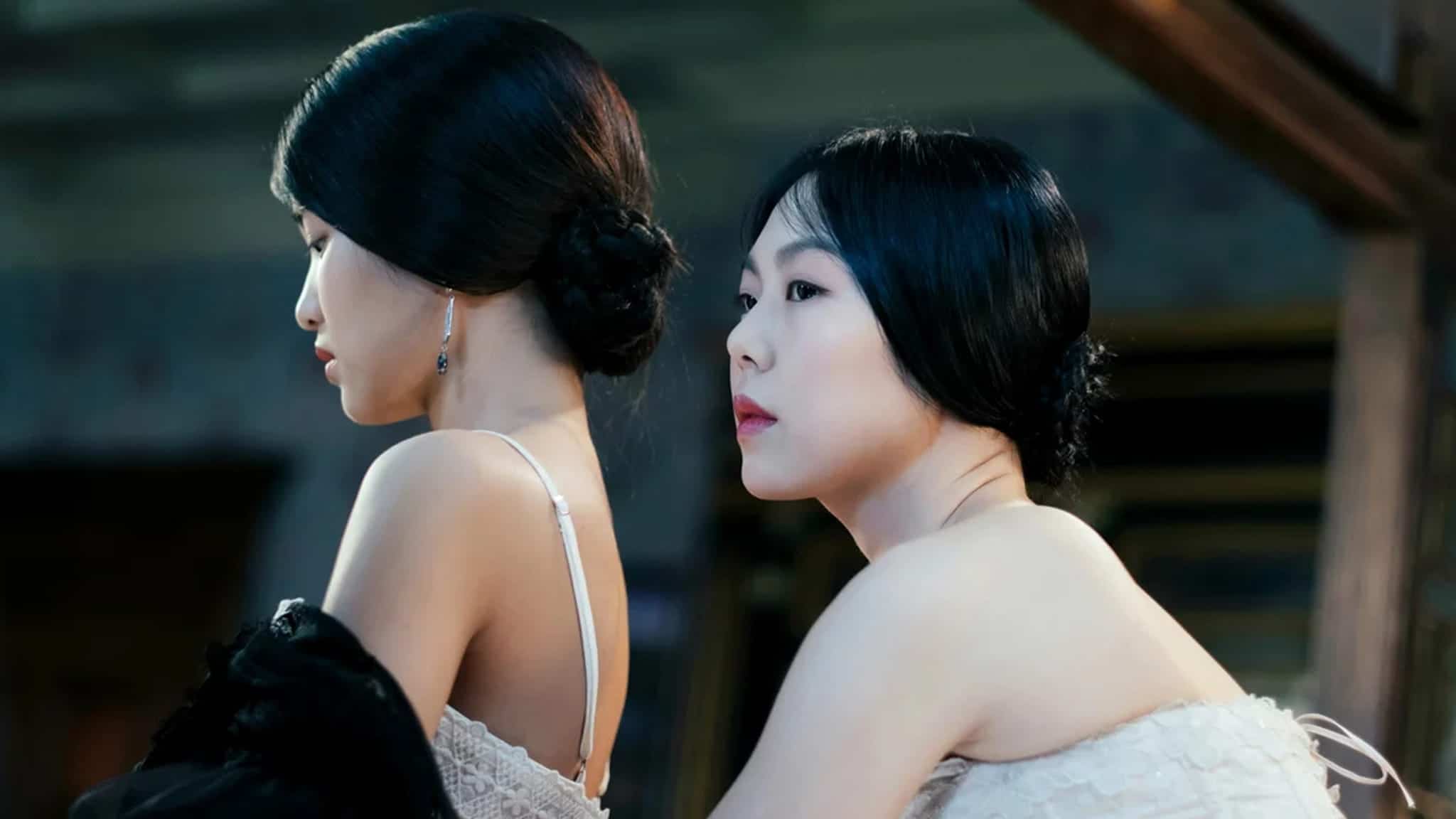 Two women with dark hair styled in buns looking in different directions.