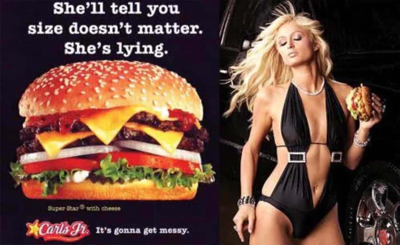A woman in a black swimsuit holds a large burger. Next to her, text reads, Shell tell you size doesnt matter. Shes lying. with a burger image and Carls Jr. logo.