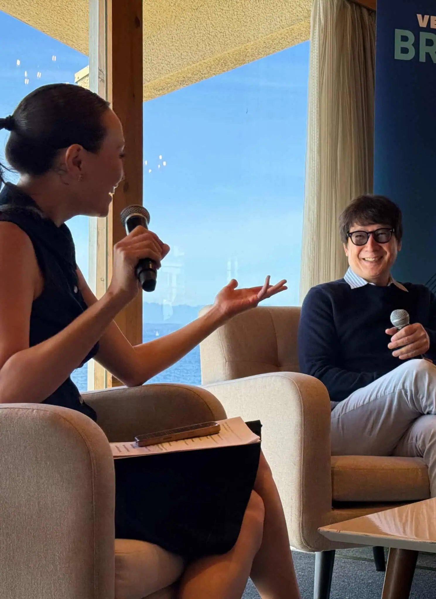 A woman interviewing a man on stage at a Very Asian Brunch benefit event.