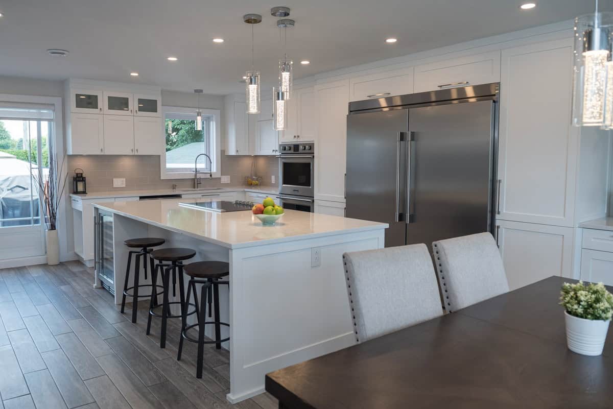 Cuisine blanche avec grand îlot et électroménagers en inox — réalisation JT Création