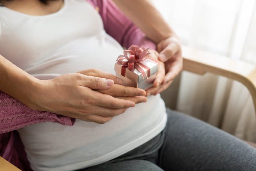 Femme enceinte recoit un cadeau de son partenaire