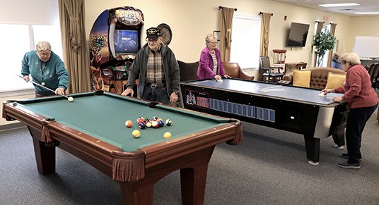 Millview residents enjoying their time in the common areas together playing pool