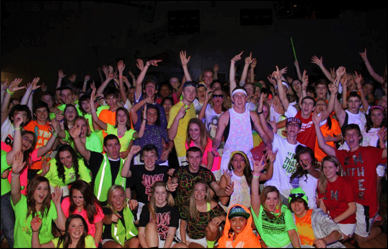 A group of people in neon vests posing for a photo at a DJ Basics event.
