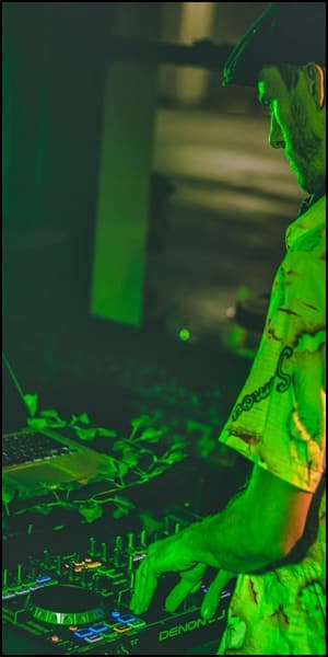 a man in a green shirt is using a laptop.