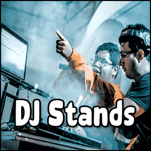 Two DJs wearing headphones stand at a DJ booth with equipment, DJ Laptop Stands, and a laptop, surrounded by smoke, with the text "DJ Stands" overlayed on the image.