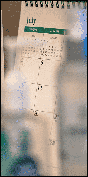 a calendar sitting on top of a table next to a bottle of water.