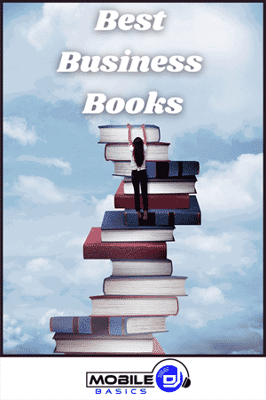 A person stands on a tall stack of oversized books reaching upward, with the text "Best Business Books" above and a "Mobile Basics" logo at the bottom—perfect for those interested in Best DJ Books and business inspiration.