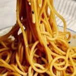A bowl of noodles with sesame seeds in it.